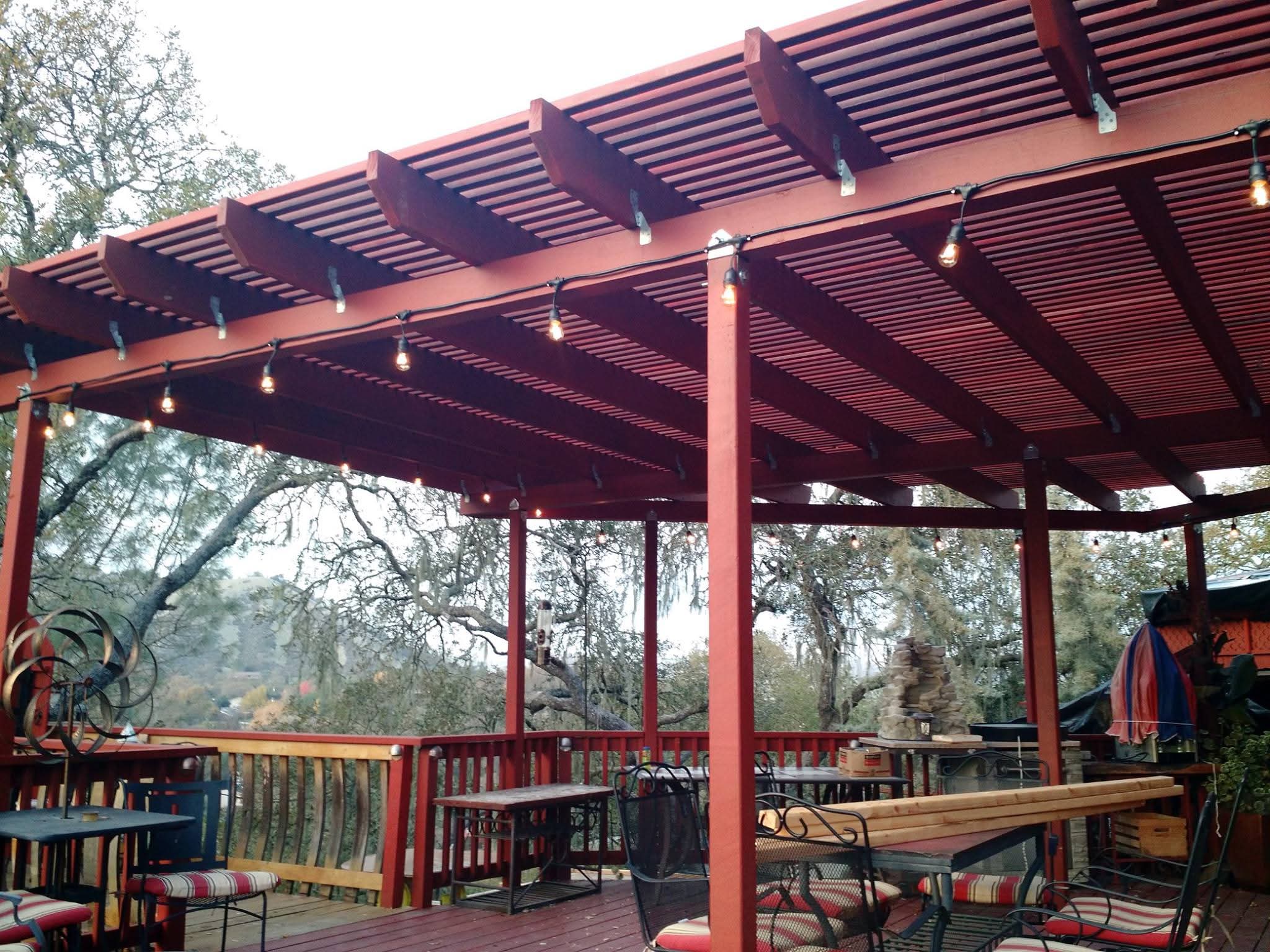 Wood pergola deck with string lights overlooking hills